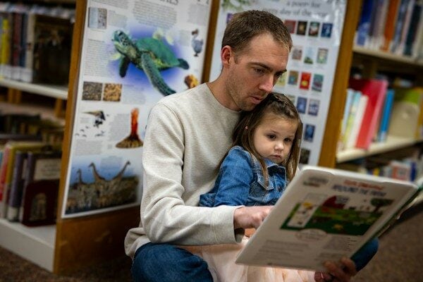 Father and daughter enjoy reading a book together